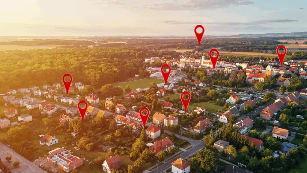 Aerial view of a suburban neighborhood at sunset, with several red location markers highlighting homes that rank in Top 3 for best Service or best Products within the community. Trees and fields surround the area. for Localboost.com